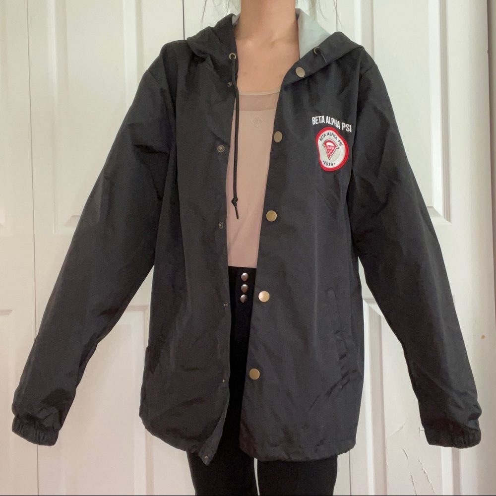 Black oversized rain jacket with Beta Alpha Psi branding